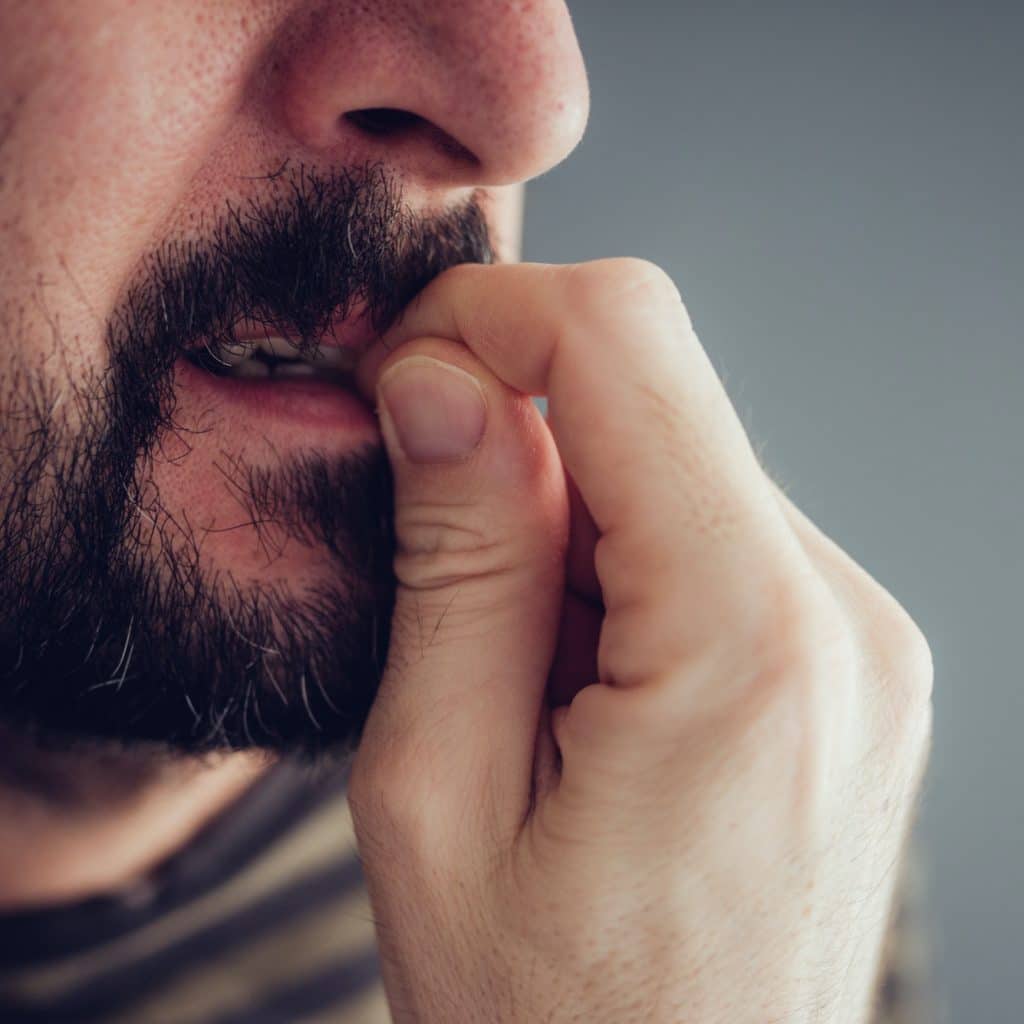 homme se ronge les ongles il a envie de craquer