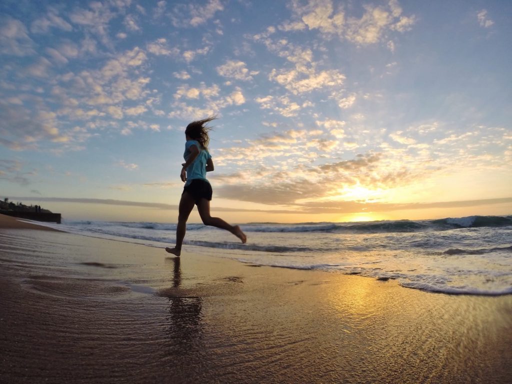 femme faisant son jogging sur la plage a besoin de glucides pour le sport