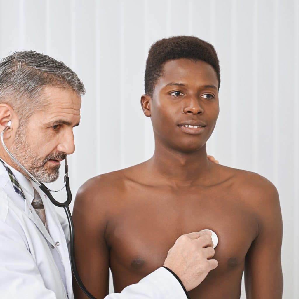 docteur écoute le coeur d'un jeune homme au stéthoscope