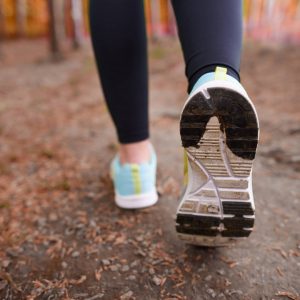gros plan sur les baskets d'une femme qui coure dans la forêt