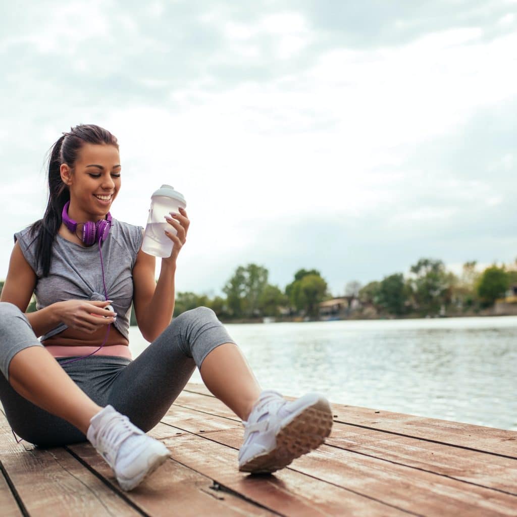 femme se assise au bord de l'eau sent bien après le sport