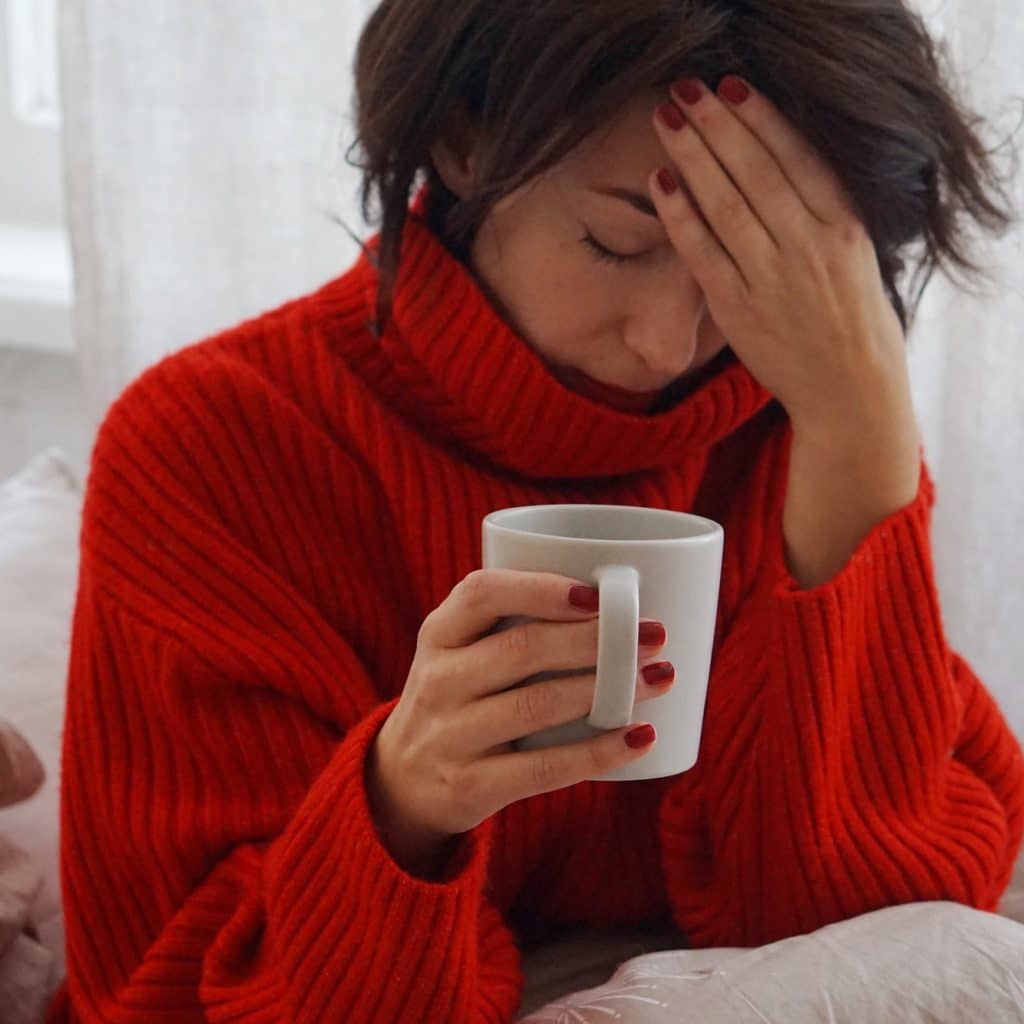 femme a une migraine et se tient la tête