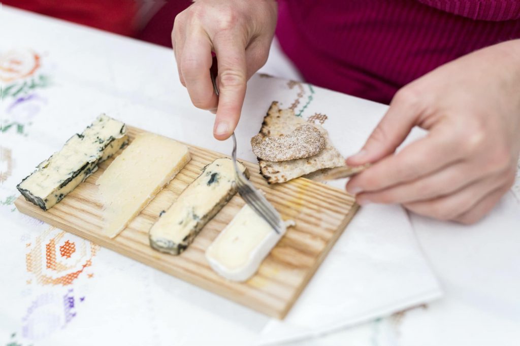 zoom sur des mains coupant du fromage