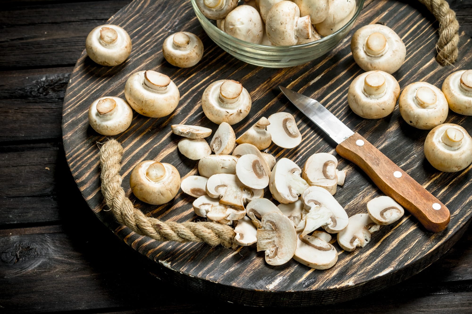 champignons coupés et couteau sur un plateau