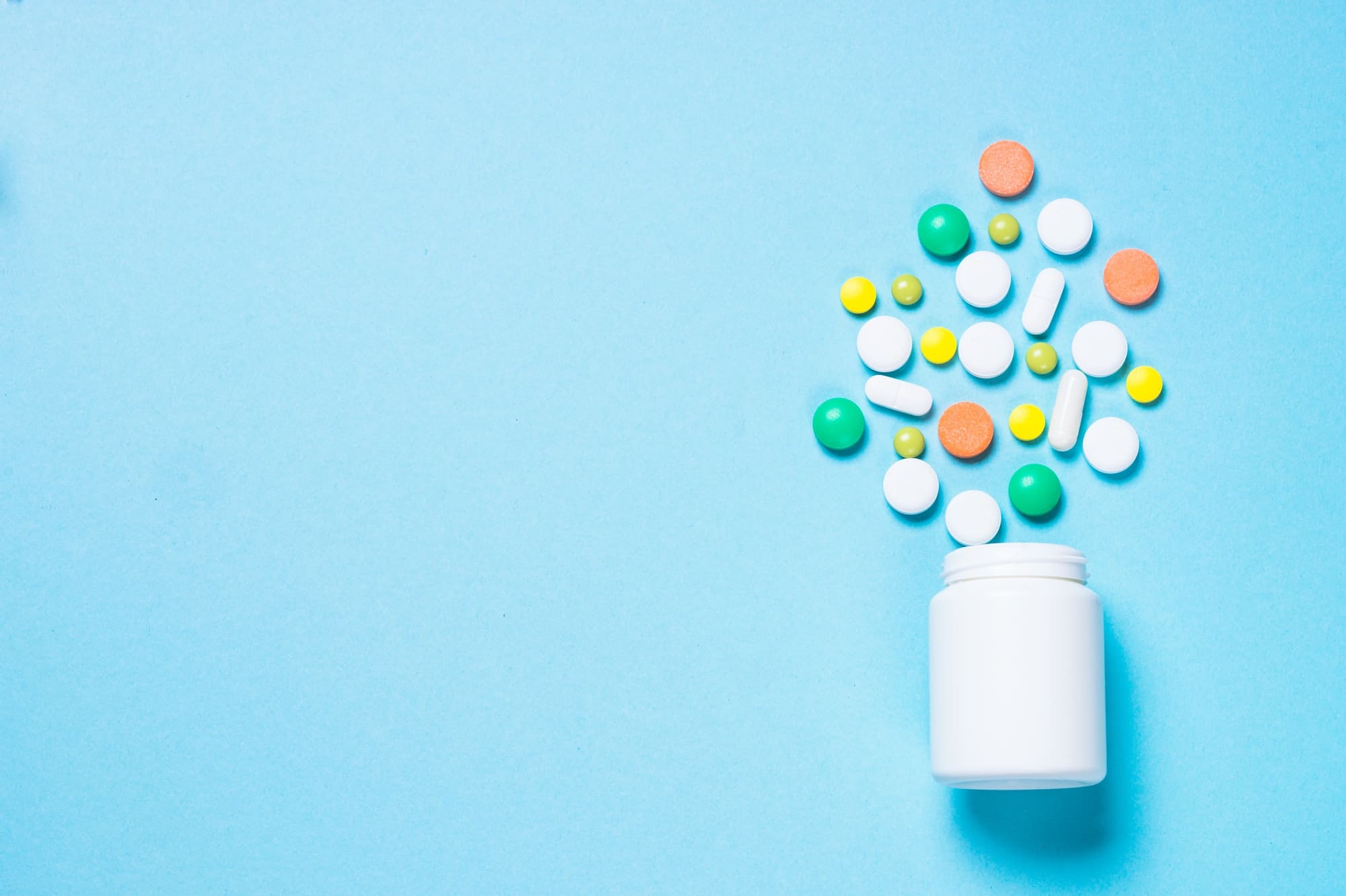 boite de complément multivitaminé sur fond bleu