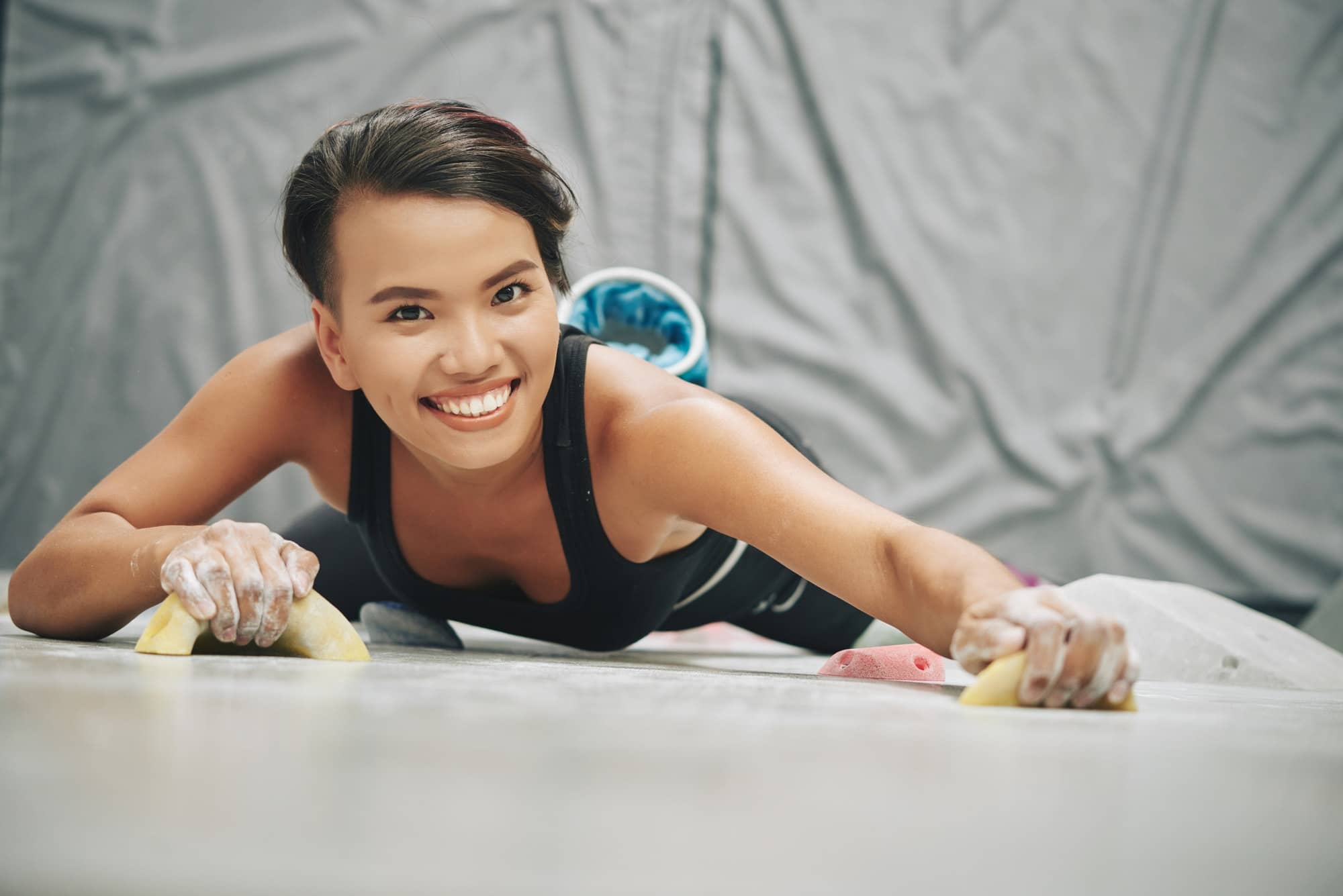 femme souriante fait de l'escalade