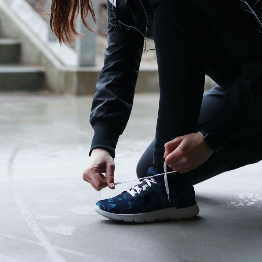 femme fait ses lacets pour aller faire du sport