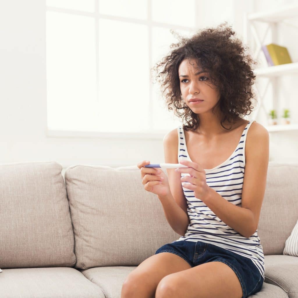 femme triste avec un test de grossesse dans les mains