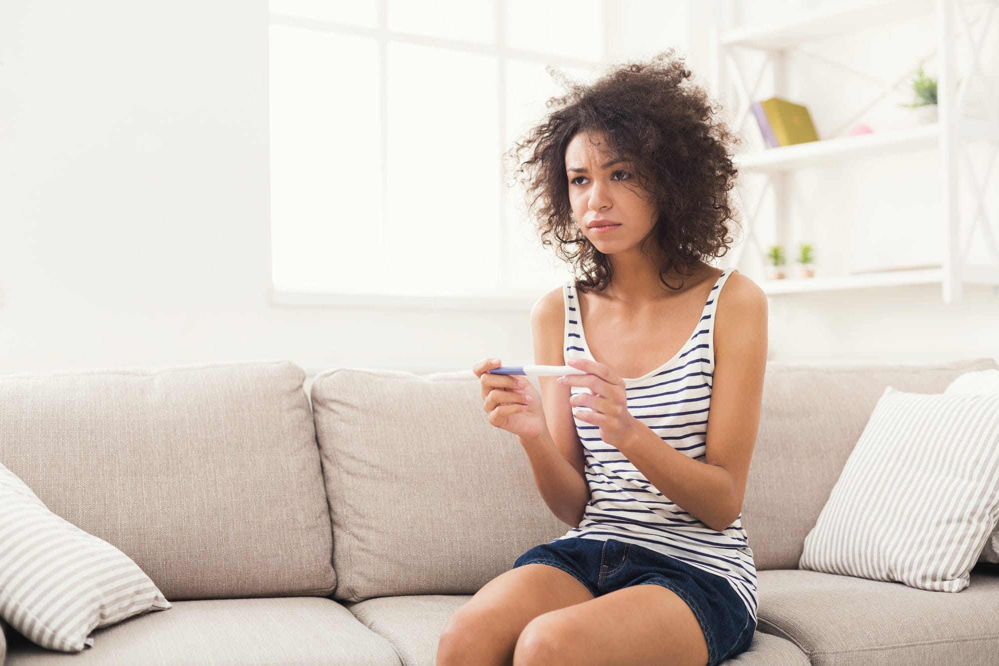 femme triste avec un test de grossesse dans les mains