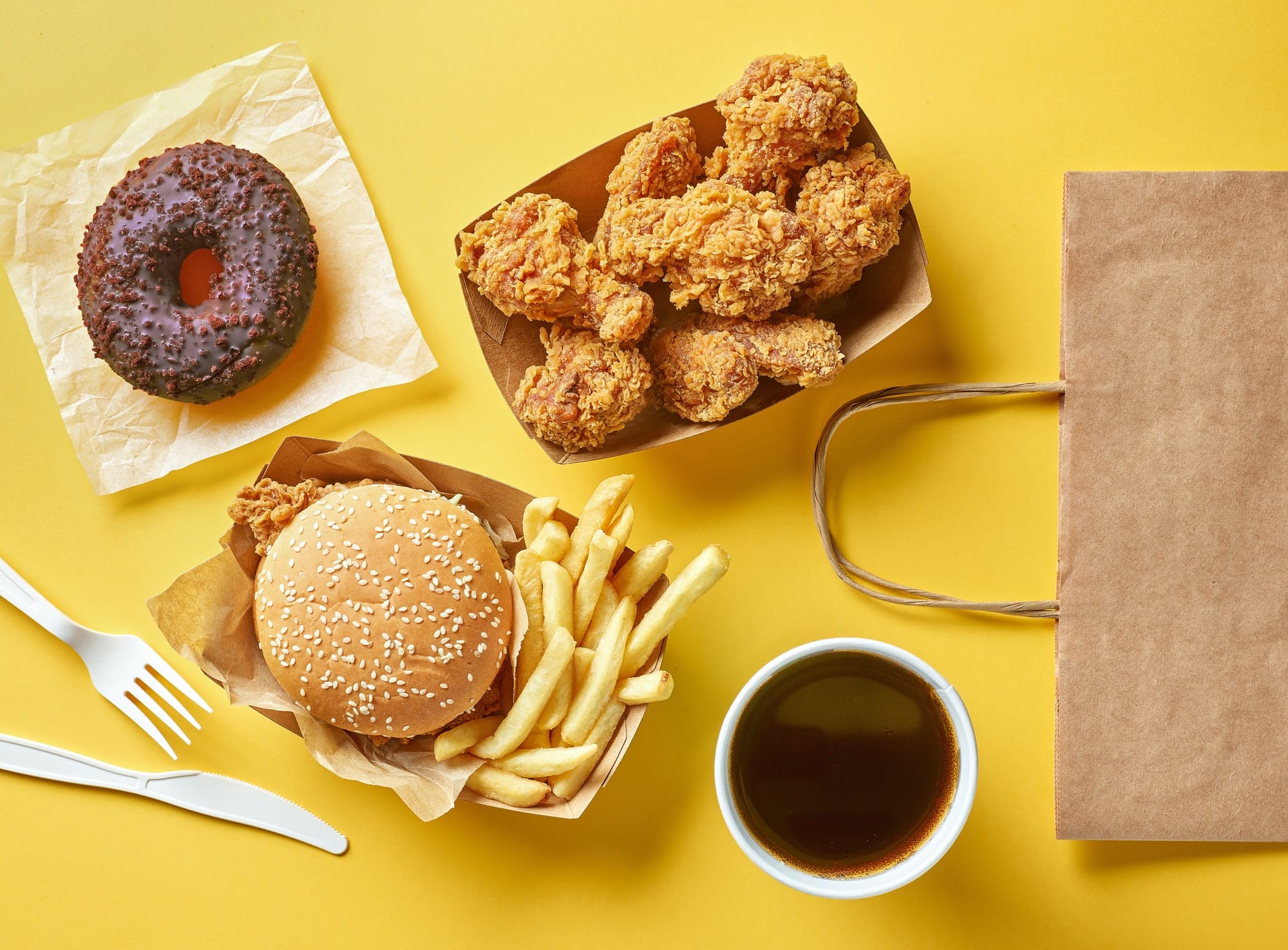 burger donut frites nuggets et café sur fond jaune