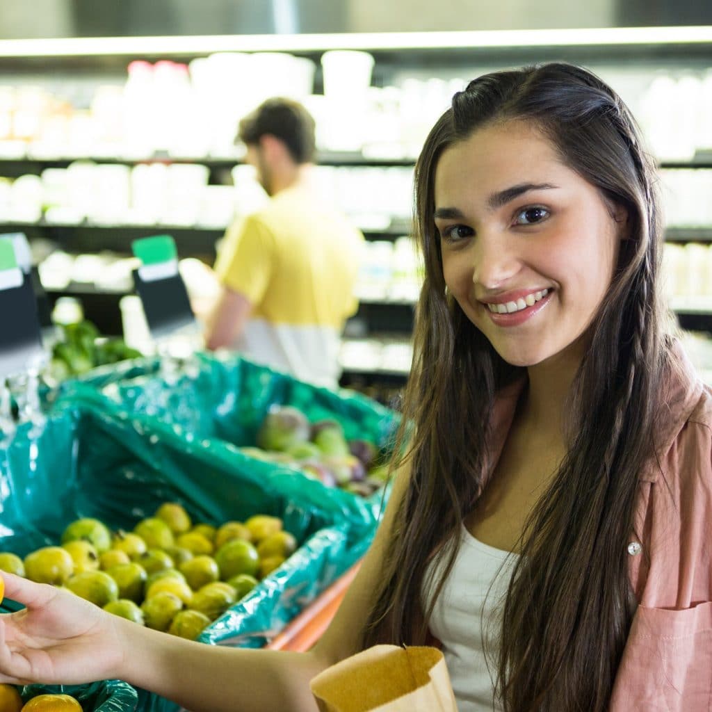 femme achète des fruits frais dans un magasin paléo